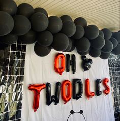 balloons that spell out the word oh tuddles on a white backdrop with black and red balloons