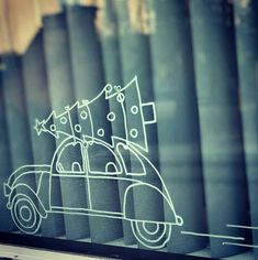 a car with a christmas tree on top is drawn in the window sill by hand