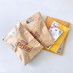 two brown envelopes sitting next to each other on top of a white countertop