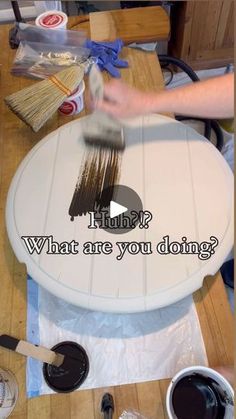 someone is painting a white table with brown paint and the words what are you doing?