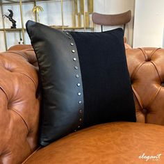 a brown leather couch with a black pillow on it