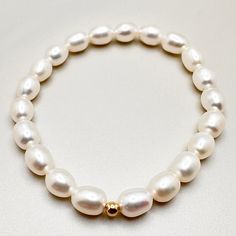 Embrace the beauty of simplicity with this Minimalist Freshwater Pearl Bracelet. The high-quality freshwater pearl takes center stage, enhanced by a 14K gold filled bead for an added touch of elegance. This bracelet is a testament to the allure of minimalism, offering a refined and timeless piece that effortlessly elevates any ensemble with its understated sophistication. MATERIALS: Metal: 14K Gold filled Beading String: Stretchable Crystal String Pearls: High-luster freshwater pearls DIMENSIONS Two Options: -wrist circumference: 4.7inches -5.1inches(~13cm) -wrist circumference: 5.5inches -5.9inches(~15cm)   PROCESSING & SHIPPING All of my pieces are shipped from the US, and I currently ship to customers in the US and Canada. I offer free shipping on all orders within the US. Shipping time Unique Jewelry Necklace, Pearl Bracelet Gold, White Pearl Bracelet, Sweet Jewelry, Hematite Bracelet, Baroque Pearl Necklace, Garnet Pendant, Freshwater Pearl Bracelet, Unisex Bracelets