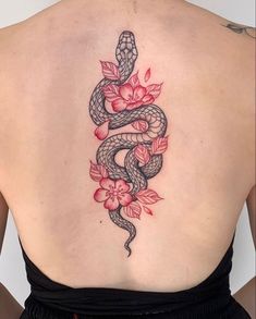 a woman's back with a snake and flowers on it