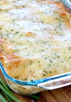 a casserole dish with cheese and green beans on a wooden table, ready to be eaten