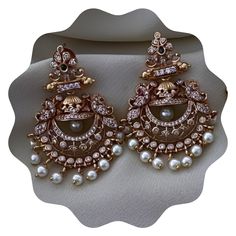 Elevate your look with our stunning Gold Plated Pearl Jhumka Earring Set, a masterpiece of traditional Indian jewelry design. Adorned with radiant Kemp stones and pearls, these handcrafted earrings offer a touch of timeless elegance for any occasion. Perfect for weddings, festivals, or casual outings, this set includes both Jhumka and Chandbali-style earrings, providing versatility and beauty in one package. Features: 💎Gold Plated Finish: The earrings are plated with high-quality gold, offering Antique Kundan Earrings, Luxury Chandbali Danglers With Pearl Drop, Luxury Party Jhumkas With Meenakari, Luxury Traditional Yellow Gold Jhumkas, Luxury Festive Jhumkas For Reception, Affordable Chandbali Chandelier Earrings For Festivals, Luxury Jeweled Temple Jewelry Jhumkas, Luxury Diamond Hand Set Jhumkas, Luxury Bridal Chandbali Earrings With Elegant Design