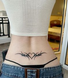 a woman's lower back tattoo with two hearts on her stomach and an arrow in the middle