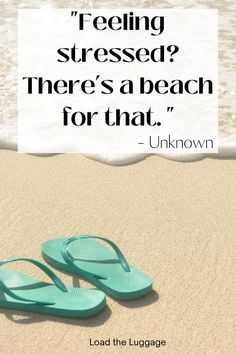 a pair of blue flip flops sitting on top of a sandy beach