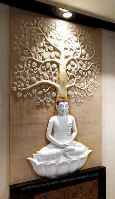 a white buddha statue sitting in front of a tree