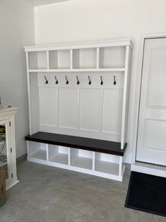 a white bench and some shelves in a room