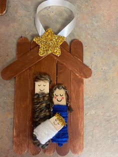 an ornament made out of wood with two people in a mangerau