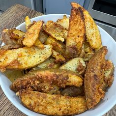 there is a white plate with some fries and celery in the bowl next to it