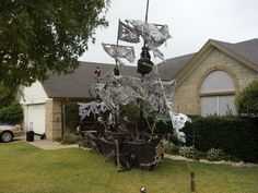 a pirate ship sculpture in front of a house