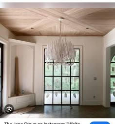 an empty room with a chandelier hanging from the ceiling