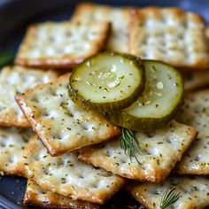 crackers with cucumber and dill on them are served on a plate