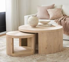 a coffee table with two stools and a vase on it in front of a couch