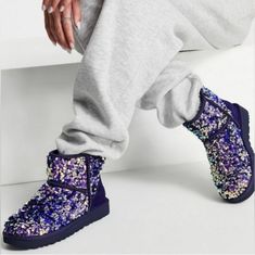 Get Ready To Shine With These Ugg Classic Mini Stellar Sequin Booties! Perfect For Any Occasion, These Ankle Boots Feature A Round Toe And Easy Pull-On Closure. The Flat Heel Style Makes Them Comfortable For All-Day Wear, And The Lined Interior Is Made Of Soft Sheepskin For Added Warmth. With A Stunning Purple Color And Bohemian Theme, These Ugg Boots Are Sure To Turn Heads. Perfect For Winter, Fall Or Spring, They're A Great Choice For Travel, Parties, Or Casual Wear. Available In Uk Size 5, Us Sparkle Uggs, Ugg Rain Boots, Ugg Boots Tall, Mini Boots, Ugg Classic Tall, Black Winter Boots, Bohemian Theme, Bailey Bow Uggs, Black Uggs