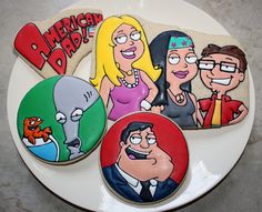 three decorated cookies sitting on top of a white plate with cartoon characters painted on them