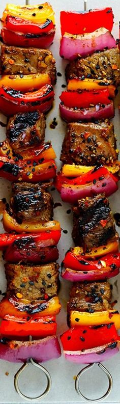 grilled hamburgers with peppers and onions on a sheet of parchment paper, ready to be served