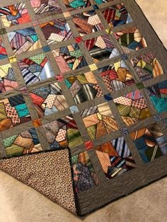 a multicolored quilt is laying on the floor with it's edges cut off