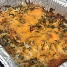 a casserole dish with cheese and vegetables in it sitting on a stove top