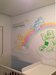 a baby's room with a teddy bear mural on the wall and rainbow painted on the wall