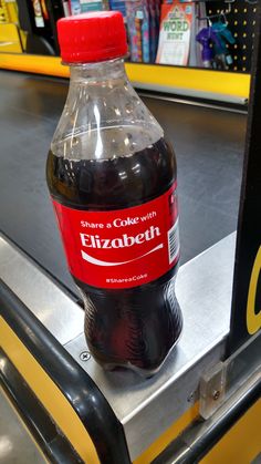 a bottle of coke sitting on top of a conveyor belt