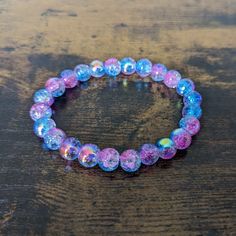 This delightful shimmering bracelet is made with 8mm round glass beads with a pink and blue crackle effect. It is great for stacking or can be worn on its own. Great care has been taken to ensure that your bracelet has been assembled securely. However, please keep in mind the nature of elastic cord and take care not to over-stretch your bracelet and risk breakage. To extend the life of your bracelet and keep the beads from fading, avoid contact with water, sweat, chemicals, or prolonged direct sunlight. Please message me with any questions. For matching earrings: https://www.etsy.com/shopcraftyoctopus/listing/1662700373 To see other bracelet options, check out my full store: https://www.etsy.com/shop/shopcraftyoctopus/ Glass Bead Bracelet, Blue Sparkle, Fancy Beads, Blue Sparkles, Crackle Glass, Knoxville Tn, Glass Beaded Bracelets, Bracelet Stack, Bead Bracelet