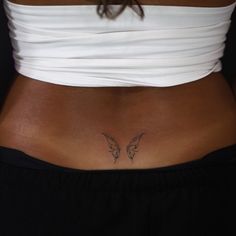 a woman's stomach with an angel tattoo on her lower body and the bottom part of her abdomen