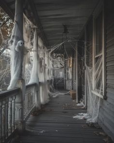 the porch is covered in ghost - like fabric and has been decorated for halloween with spooky decorations