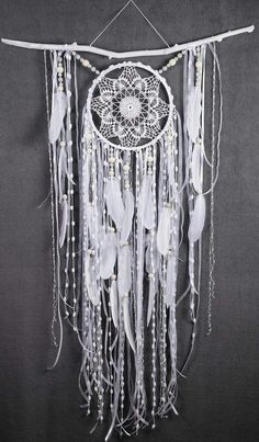 a white dream catcher hanging on a wall