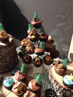 cupcakes are arranged in the shape of a tree stump and on display with pine cones