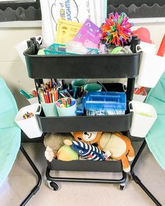 a three tiered cart filled with lots of toys and books on top of a floor