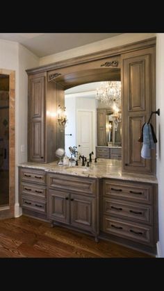 a large bathroom with marble counter tops and wooden cabinets, along with a chandelier