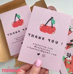 a person holding up some pink cards with cherries on them and the words thank you