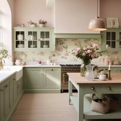 a kitchen with green cabinets and pink walls