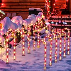 many candy canes are lit up in the snow