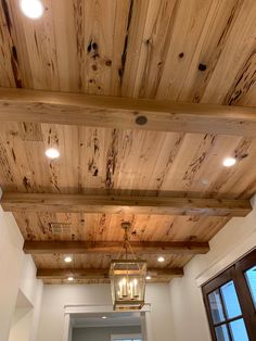 a light fixture hanging from the ceiling in a room with white walls and wood paneling