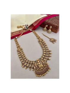 A beautiful South Indian style temple bridal jewelry set to keep traditions alive ! Unfold the euphoria of majestically embossed gold bridal jewelry set in an enticing temple design that will make sure to elevate your look.  The comprises of 4 pcs. A long necklace,  a pair of jhumka earrings and a maang tika.  Details: Necklace Length-12.5 Inches Necklace Width-7.25 Inches Earrings Length-2.25 Inches Weight of Each Earring-16 gms Maang Tika Length-5 Inches All products are manufactured using traditional skills from our rich heritage of crafts.  The process of these crafts is essentially manual. Hence, any irregularities or variations are an inherent part of these handcrafting processes. Gold Wedding Set, Indian Jewelry Set, Jewelry Set Gold, South Indian Bridal Jewellery, Maang Tika, Indian Bridal Jewelry, Indian Bridal Jewelry Sets, Gold Bridal Jewellery Sets, Bridal Jewelry Set