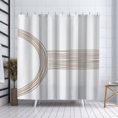 a white shower curtain in a bathroom with black and white tiles on the floor next to a chair