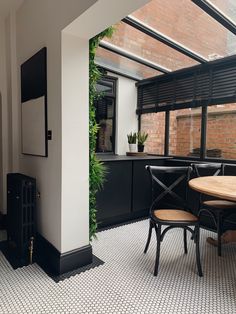 an outdoor dining area with black and white tile flooring, potted plants on the wall