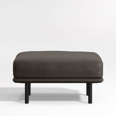 a grey ottoman sitting on top of a white floor