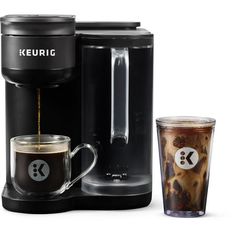 the keurig coffee maker is next to a cup of coffee and a shot glass