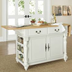 a kitchen island with lots of food on top of it in the middle of a room