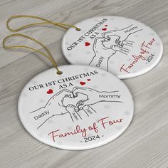 two personalized christmas ornament with hands holding each other and the words, our first christmas as family of four