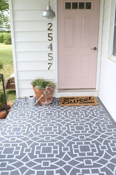 a front porch with a door mat and potted plants