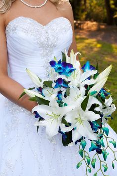 a bride holding a bouquet of white and blue flowers