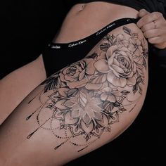 a woman's thigh with flowers and arrows on the side, showing her stomach