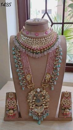 an elaborate necklace and earring set is displayed on a mannequin in front of a window