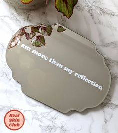 a mirror that says i am more than my reflection on it next to a potted plant