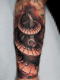 a man's leg with an artistic tattoo design on it, including piano keys